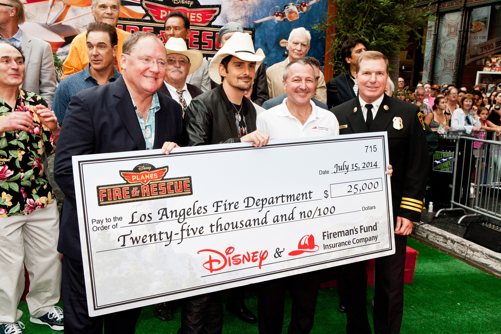 Director, John Lasseter; singer Brad Paisley; Vice President Brand Marketing, Fireman's Fund Insurance Company, Paul Fuegner; and Los Angeles Assistant Fire Chief Matthews present a check for $25,000 to the Los Angeles Fire Department as part of Fireman&rsquo;s Fund&rsquo;s Heritage Program, supporting firefighters for safer communities at the Disney premiere of Planes: Fire & Rescue Tuesday, July 15 at the El Capitan Theater in Hollywood.