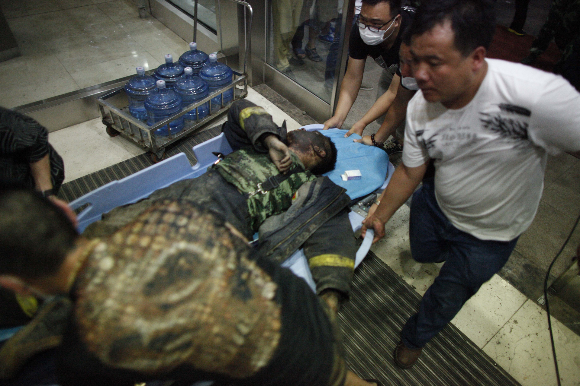 A Chinese firefighter is transported from the blast scene where a number of responders were killed or are missing.