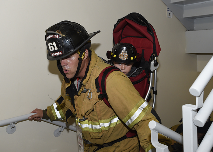 A very young future firefighter gets a lift.