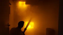 The man in the photo is not really in a fire building without turnout gear and SCBA. Rather, it's a simulated room and contents fire in BullEx's show booth and the man 'extinguishing' the fire is a representative of the company. BullEx's simulated fire board reacts to water streams, darkens down and eventually goes out with sufficient application of water. Smoke machines provide added scene realism. The man in the photo is not really in a fire building without turnout gear and SCBA. Rather, it's a simulated room and contents fire in BullEx's show booth and the man 'extinguishing' the fire is a representative of the company. BullEx's simulated fire board reacts to water streams, darkens down and eventually goes out with sufficient application of water. Smoke machines provide added scene realism.