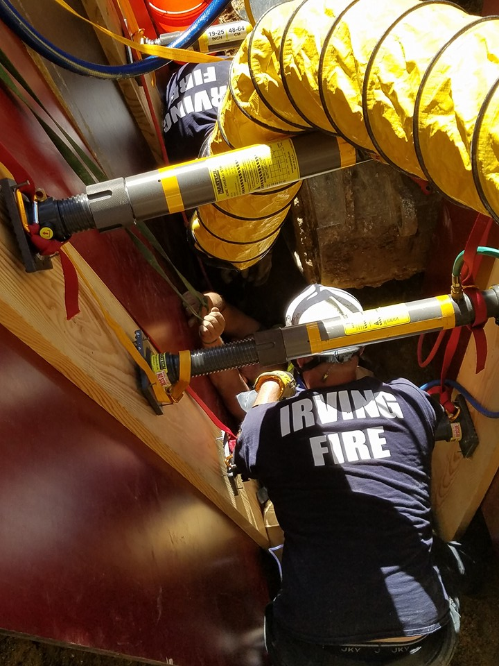 Firefighters secured the worker while they removed dirt from the collapsed trench.