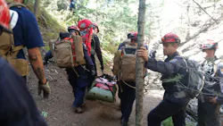 A Santa Fe (NM) Fire Department team trains using the Rapid Extraction Module (REM) in which a team of responders can extract a downed firefighter in a wildland setting. A Santa Fe (NM) Fire Department team trains using the Rapid Extraction Module (REM) in which a team of responders can extract a downed firefighter in a wildland setting.
