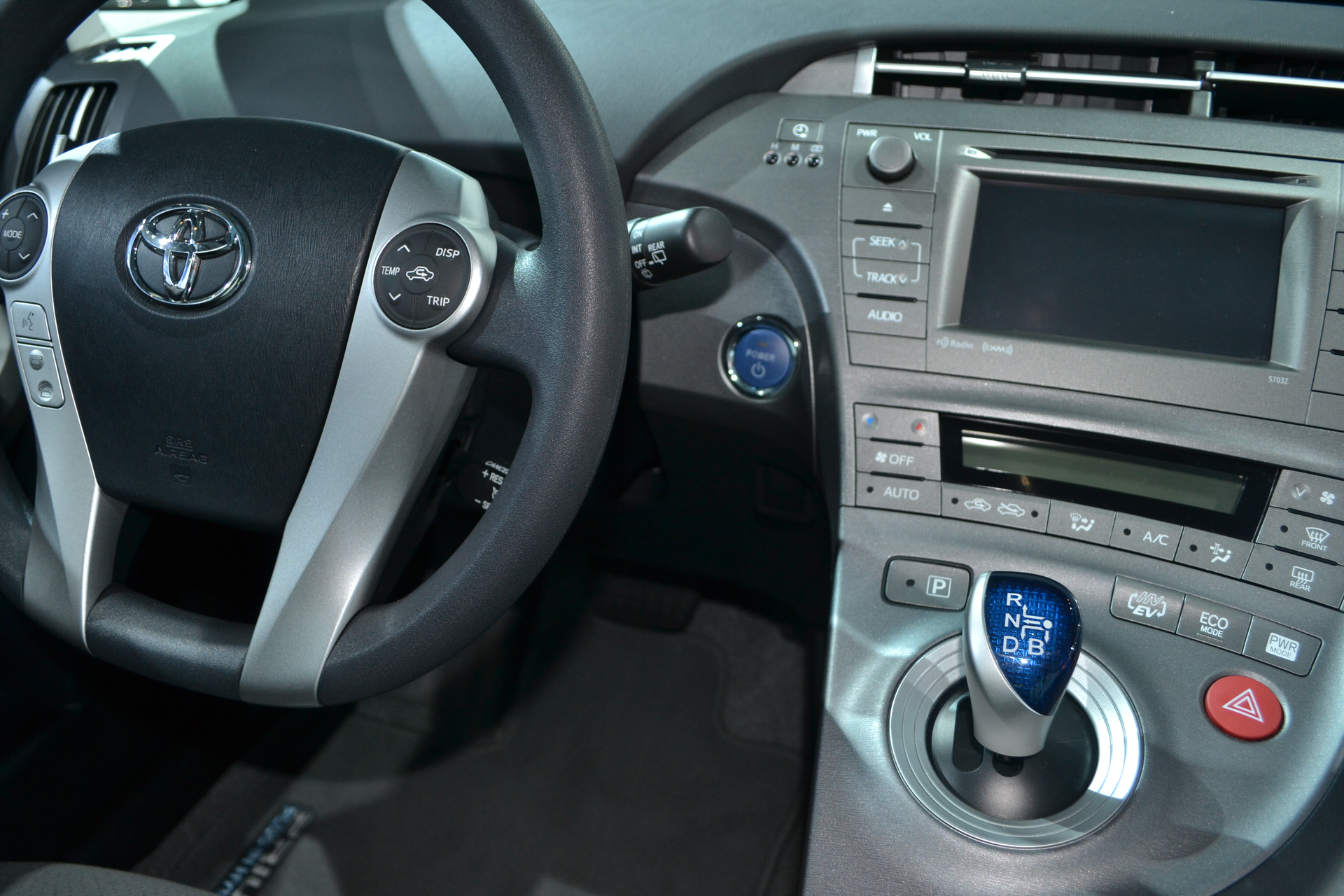 This 2015 Toyota Prius has a keyless ignition start/stop push button, an electronic parking brake button on the center console, and a joystick-type gear selector.