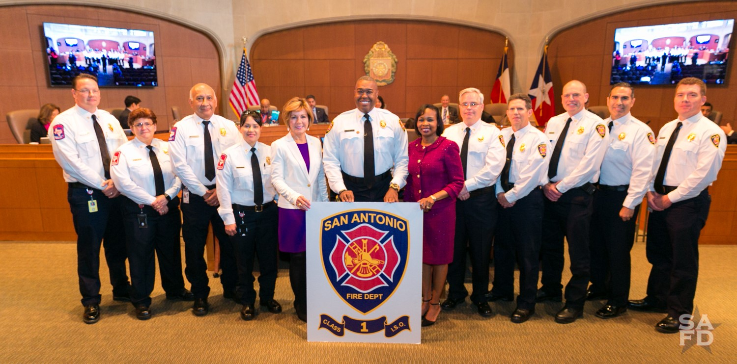 San Antonio Fire Chief Charles Hood, center, is flanked by City Manager Sheryl Sculley on his left and Mayor Ivy R. Taylor on his right along with fire department staff members as they accept the Class 1 designation award to the city's fire department by ISO.