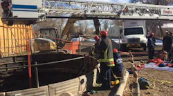 Photo 1: The bucket of Tower 1 was centered over the access point and used as the high anchor point for the 4:1 hauling system. Photo 1: The bucket of Tower 1 was centered over the access point and used as the high anchor point for the 4:1 hauling system.