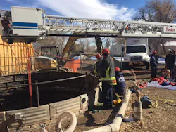 Photo 1: The bucket of Tower 1 was centered over the access point and used as the high anchor point for the 4:1 hauling system. Photo 1: The bucket of Tower 1 was centered over the access point and used as the high anchor point for the 4:1 hauling system.