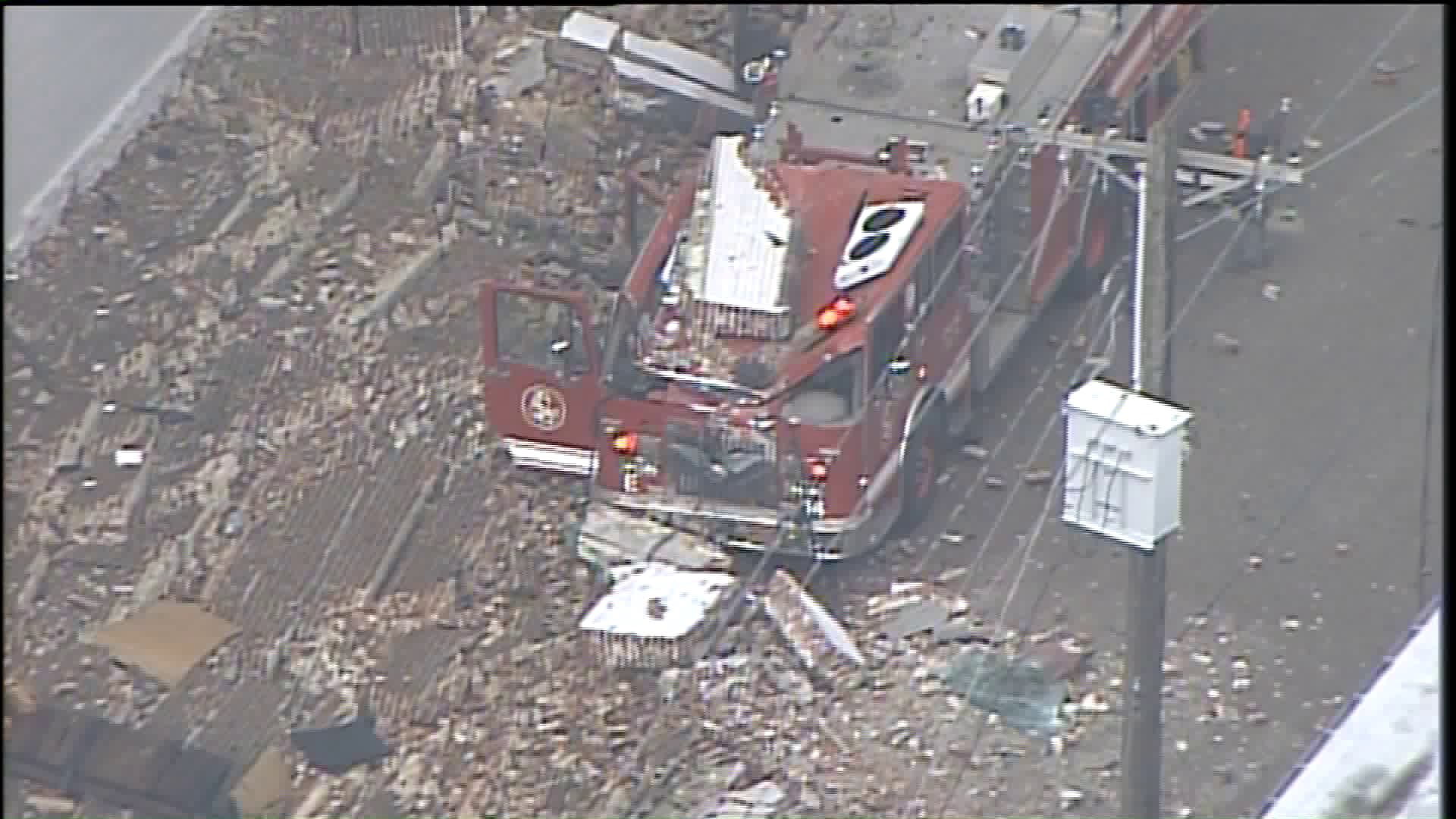 Debris can be seen atop a crushed St. Louis fire apparatus after a wall collapsed during a massive fire Wednesday at a warehouse containing over 150,000 citronella candles.
