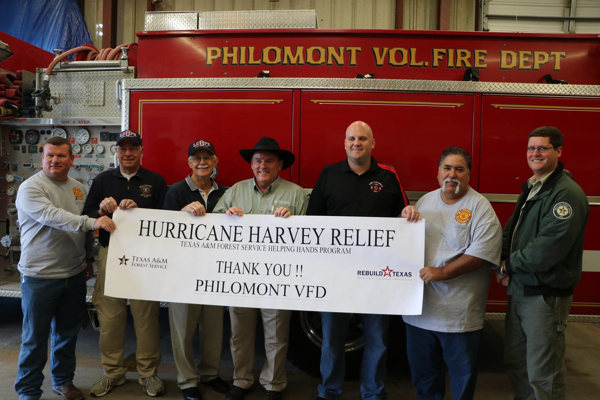 Officials from Philmont, Port Aransas and Texas A&M Forest Service pose for a photo with the donated pumper.