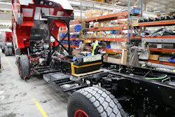 An aerial with a big block engine has the Aftertreatment components installation in progress. In this instance, the DEF tank is located in the fender panel area ahead of the rear wheel. An aerial with a big block engine has the Aftertreatment components installation in progress. In this instance, the DEF tank is located in the fender panel area ahead of the rear wheel.