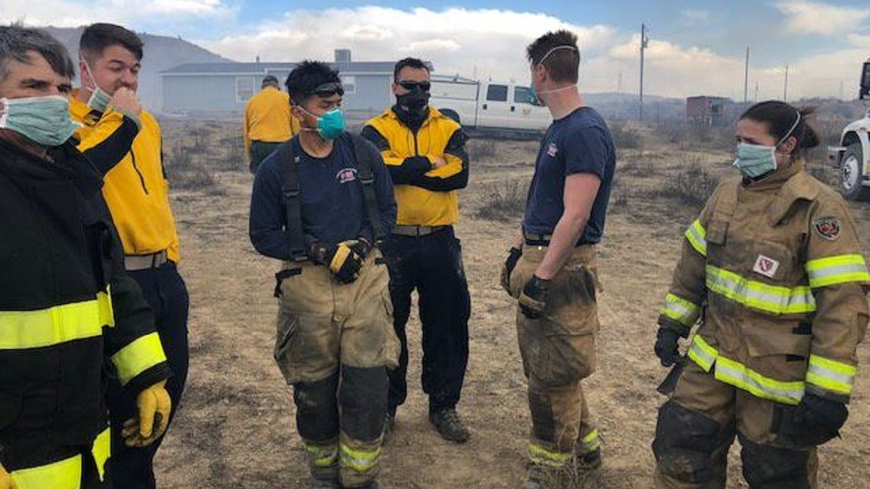 Fire crews wear breathing masks as they work near a contained tire fire in El Paso County, CO that continues to smolder and release hazardous materials.