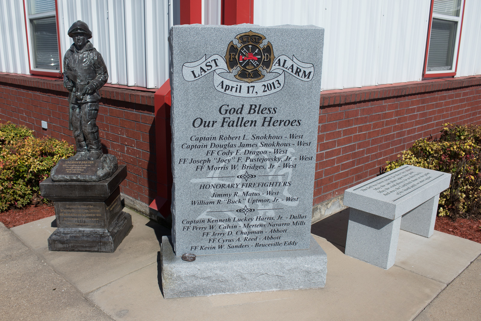 Three memorials, including a bench and a firefighter statue, are located outside the West Volunteer Fire Department's station.