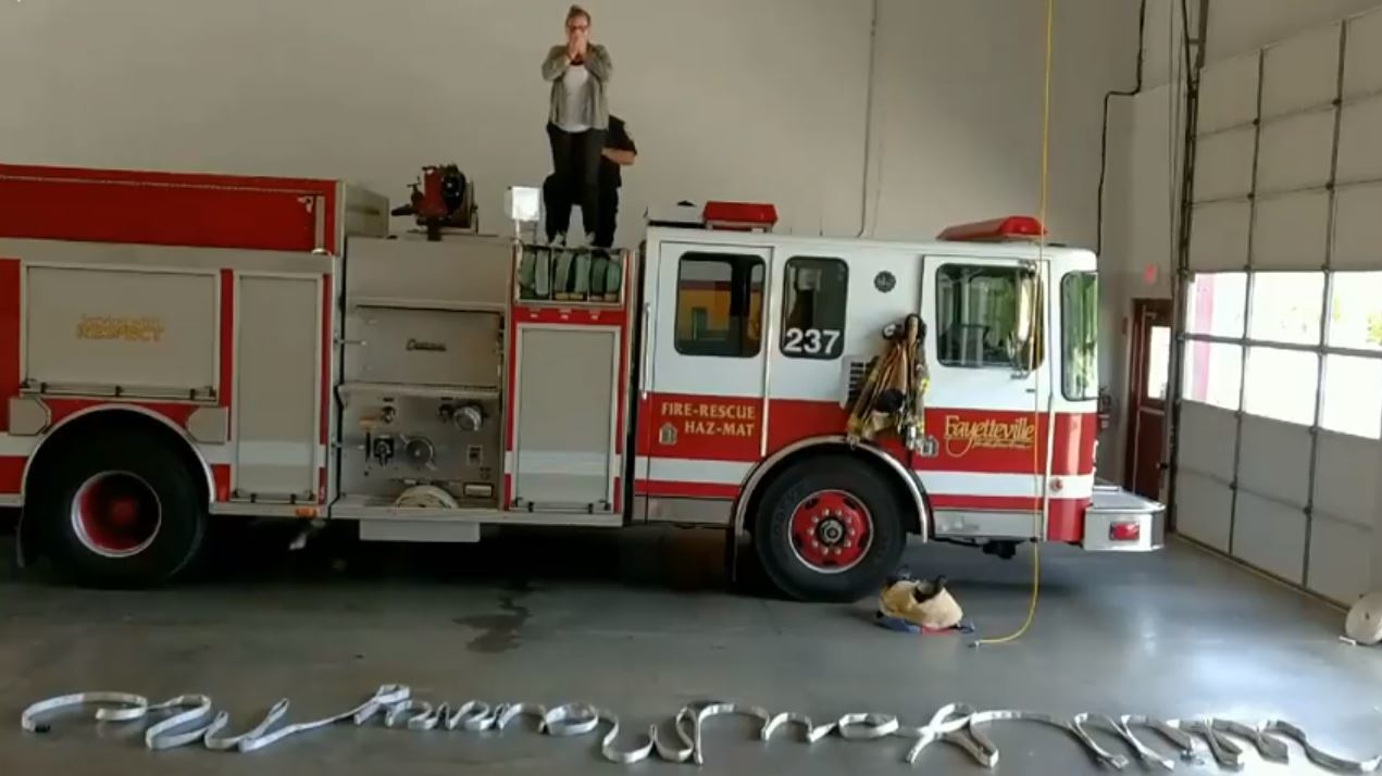 The words 'Will You Marry Me' are spelled out with a fire hose as Fayetteville, NC, firefighter Ashton Hanway proposes to his girlfriend Lauren Wood at his station on May 4, 2018.