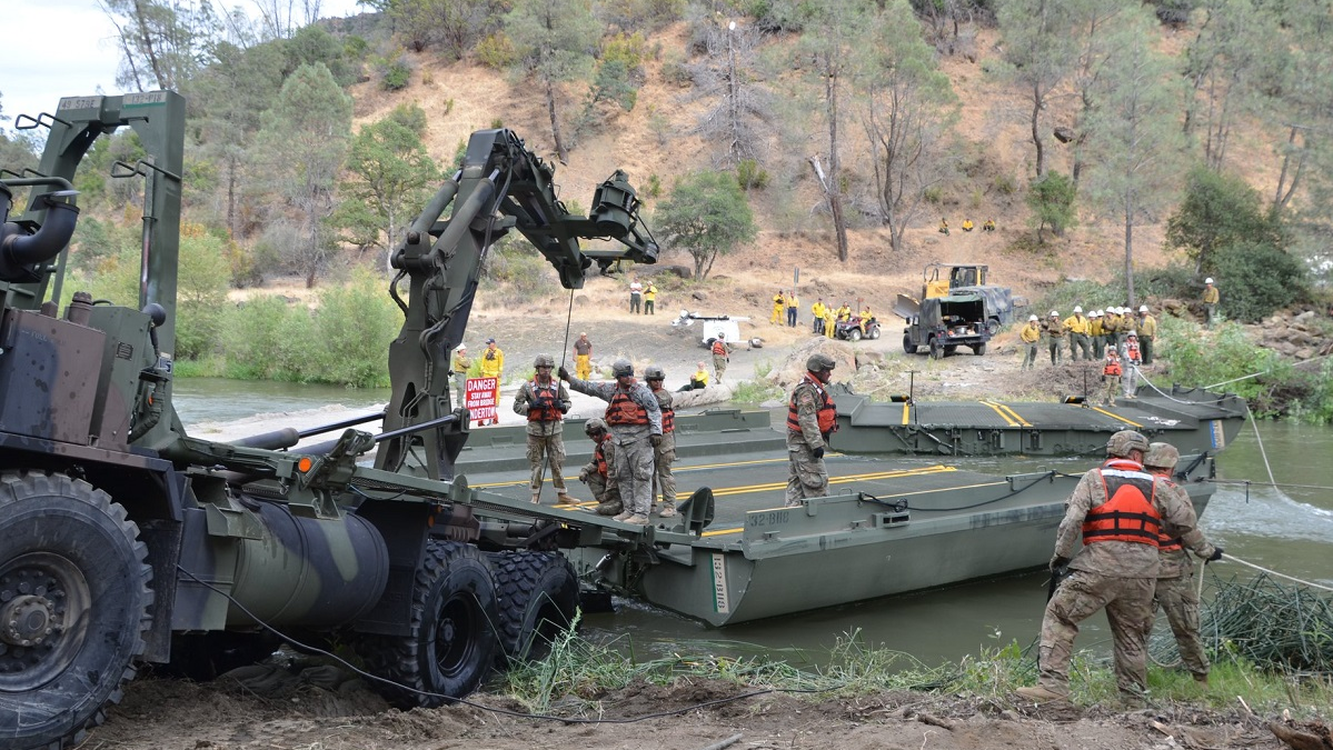 Cal Fire crews watch as members of the California National Guard build a temporary bridge across Cache Creek in Yolo County to assist them during firefighting operations.