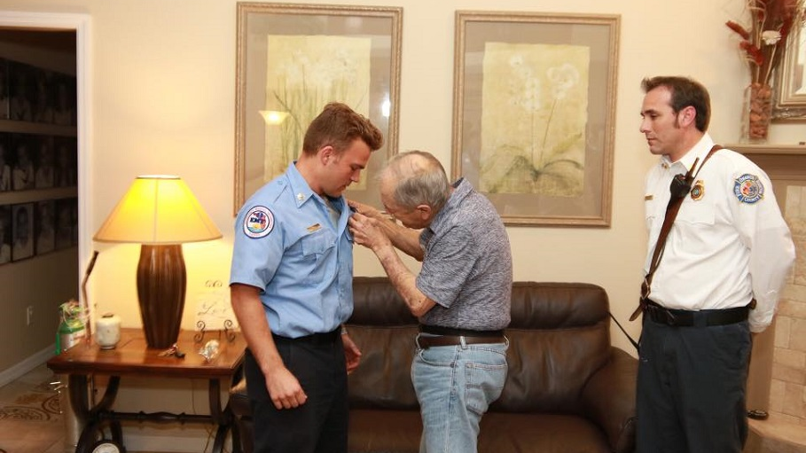 New Orange County Fire Rescue firefighter Greg Ferone receives his ceremonial pin from his father, Ed.