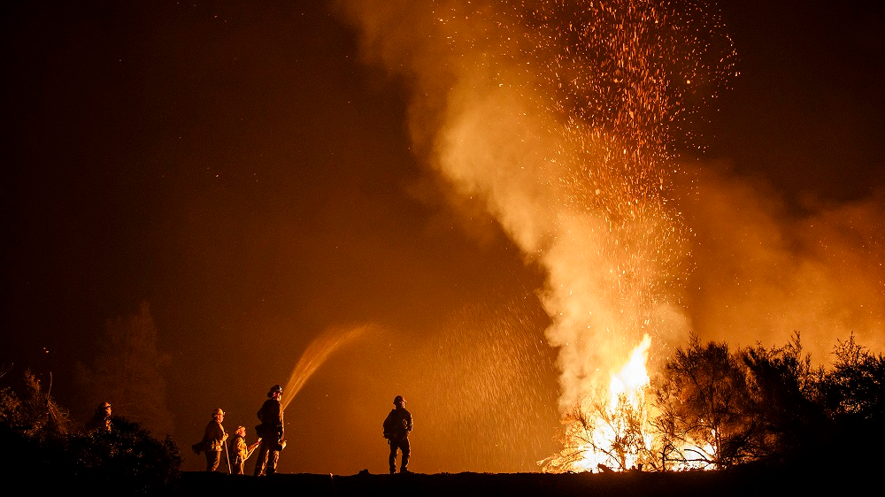 California firefighters monitor an Aug. 7 burn operation on top of a ridge near the town of Ladoga.