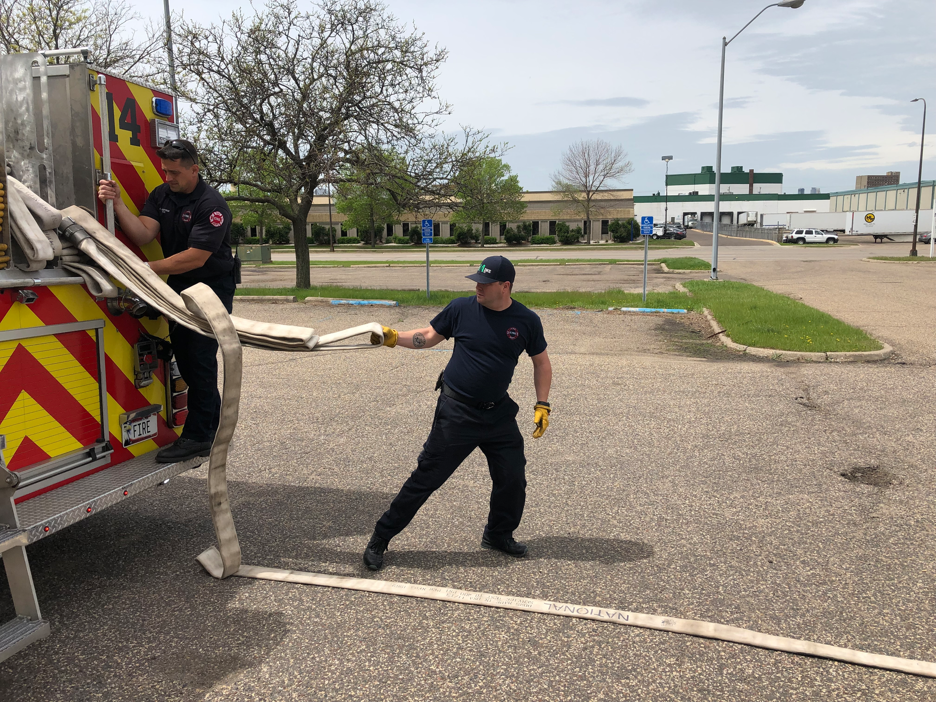 The layout firefighter pulls the largest loop to clear 100 feet of travel line from the hosebed.