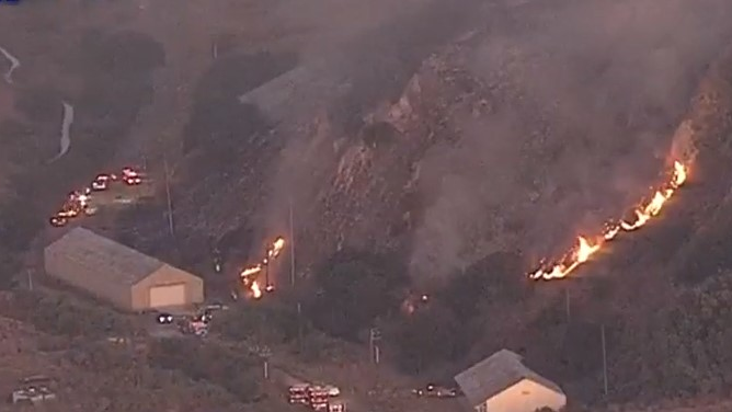 Firefighters from multiple agencies battled a five-alarm grass fire that threatened an historic Mare Island, CA, cemetery Thursday.