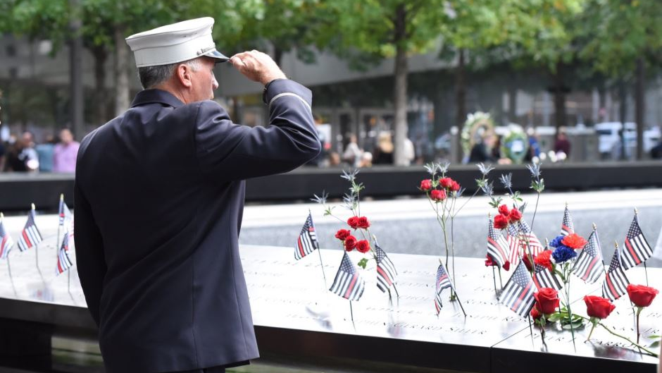 A firefighter salutes the fallen at the 9/11 Memorial in lower Manhattan on Wednesday, Sept. 11, 2019.