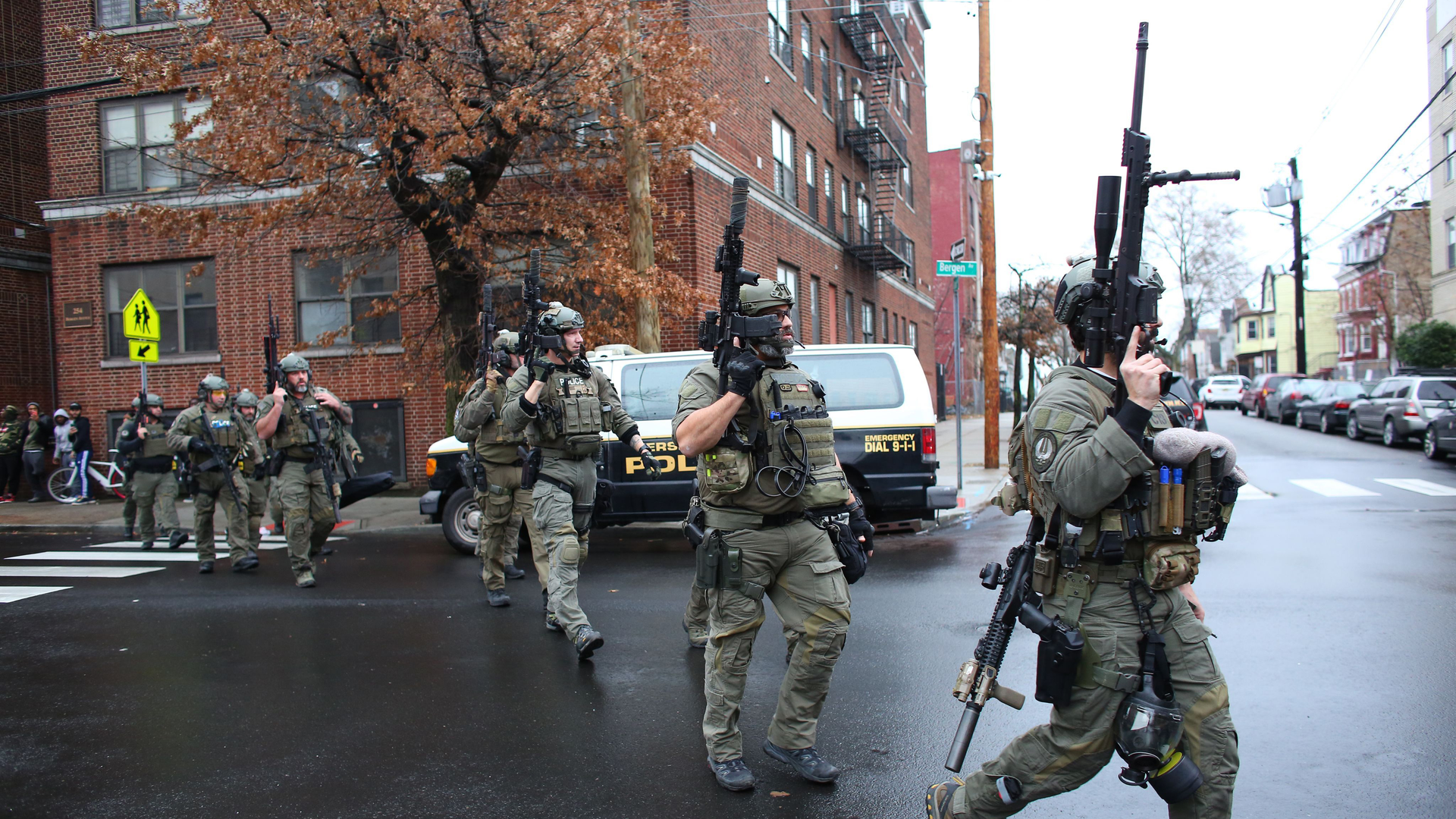 Police arrive at the scene of an active shooting Tuesday in Jersey City, NJ. One officer was fatally shot when a couple carrying long rifles opened fire.