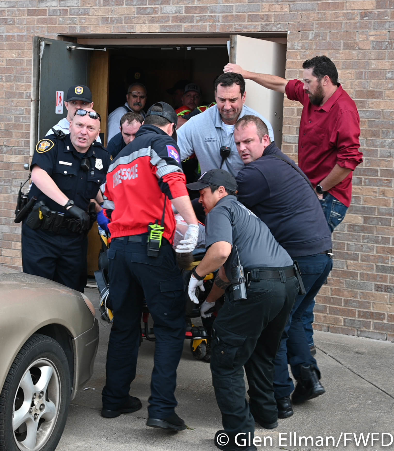 Firefighters, police and paramedic remove a victim from the scene of a shooting at a White Settlement church Sunday morning.