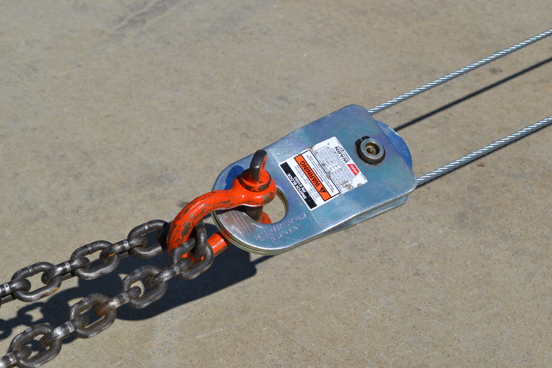 Figure 1. This running, or traveling, snatch block, which is attached directly to the load via a chain, is being used in a 2:1 mechanical advantage system. The pulling effort from the winch comes in on one side, makes a U-turn on the sheave/pulley of the snatch block and returns back to the winch vehicle&mdash;hence, two lines to the load.