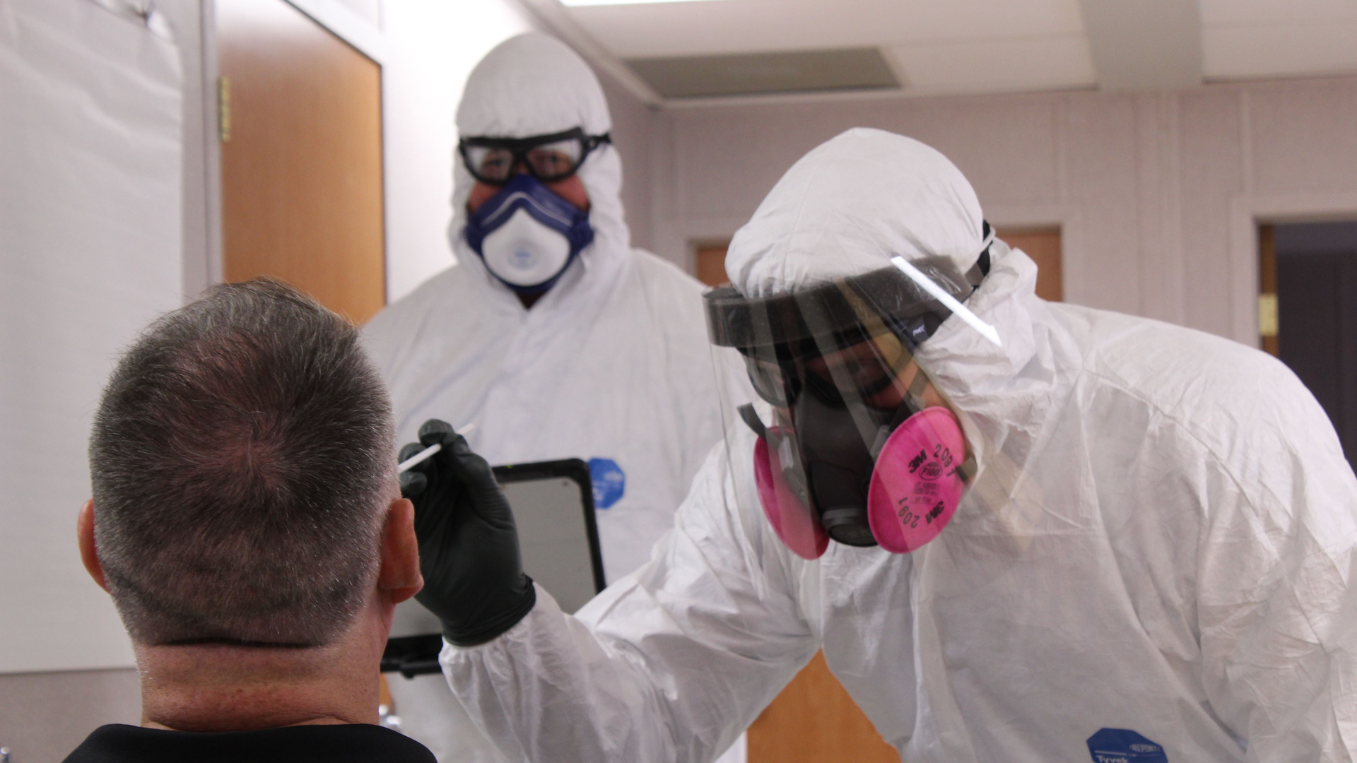 Allen, TX, firefighter and paramedic Tony Cooper (left) and Division Chief Daniel Williams administer a COVID-19 test in May 22.