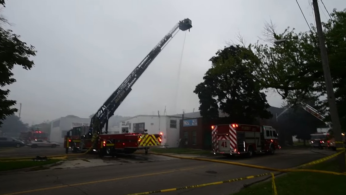 A Jackson, MI, firefighter suffered first- and second-degree burns on his upper arm during a large commercial blaze Wednesday.