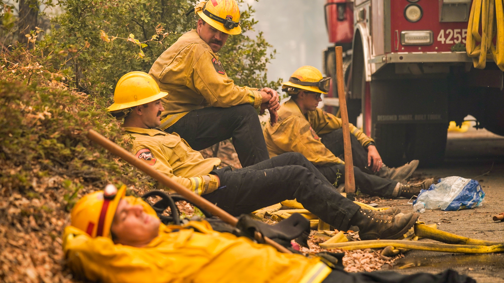 CAL FIRE firefighters (from left) Rob Spitzer, Max Kitty, Josiah Gist and Hunter Grossmann take a break during operations against the Creek Fire in Madera County, CA, on Sept. 8, 2020.
