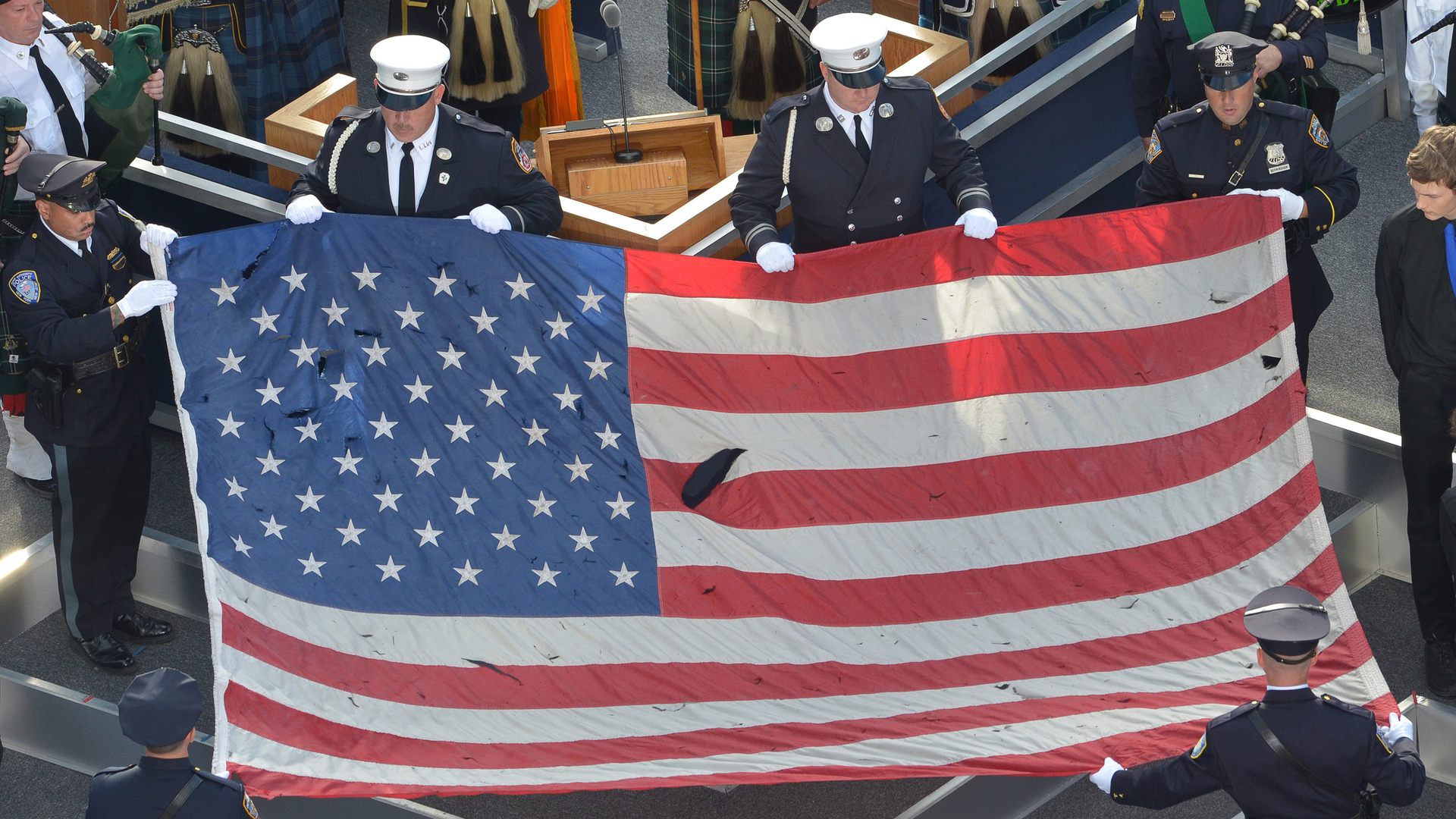 A U.S. flag recovered from the 9/11 attacks is displayed by New York City police officers and firefighters during the ceremony marking the 10th anniversary of the terrorist attack in 2011.