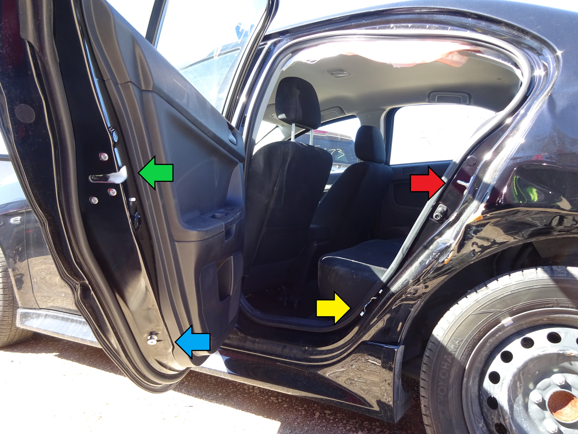 On this Mitsubishi sedan, the safety latch (green arrow) and safety lock (red arrow) are located well above the striker pin (a bolt in this case, blue arrow) and the striker plate (yellow arrow), which is on the C-pillar.