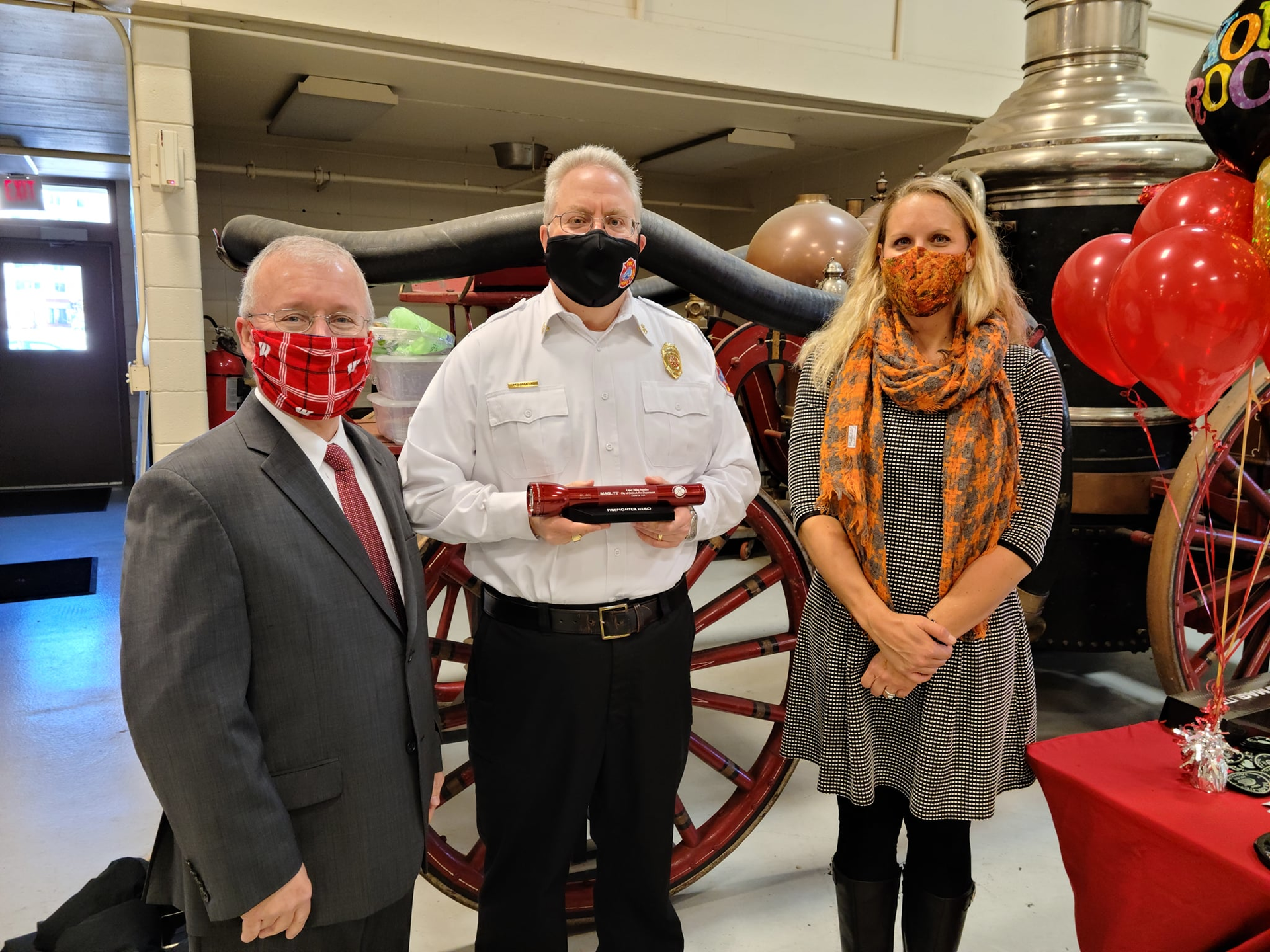 Fire Chief Michael Stanley (center) was presented with the Firefighter Hero Award by Oshkosh City Manager Mark Rohloff, and Jennifer Skolaski, who consulted with Chief Stanley on a falls prevention initiative and who nominated him for the award.