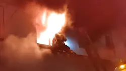 A Baltimore City firefighter avoids flames as they shoot out of a second-story window of a burning rowhouse Friday. A Baltimore City firefighter avoids flames as they shoot out of a second-story window of a burning rowhouse Friday.