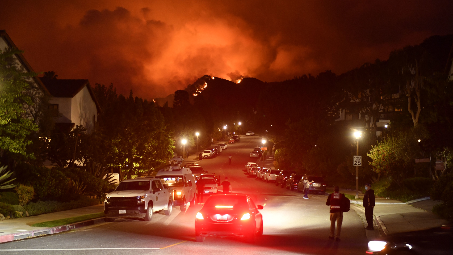 Flames from the Palisades Fire glow in the distance in Topanga, CA, northwest of Los Angeles, on May 15.