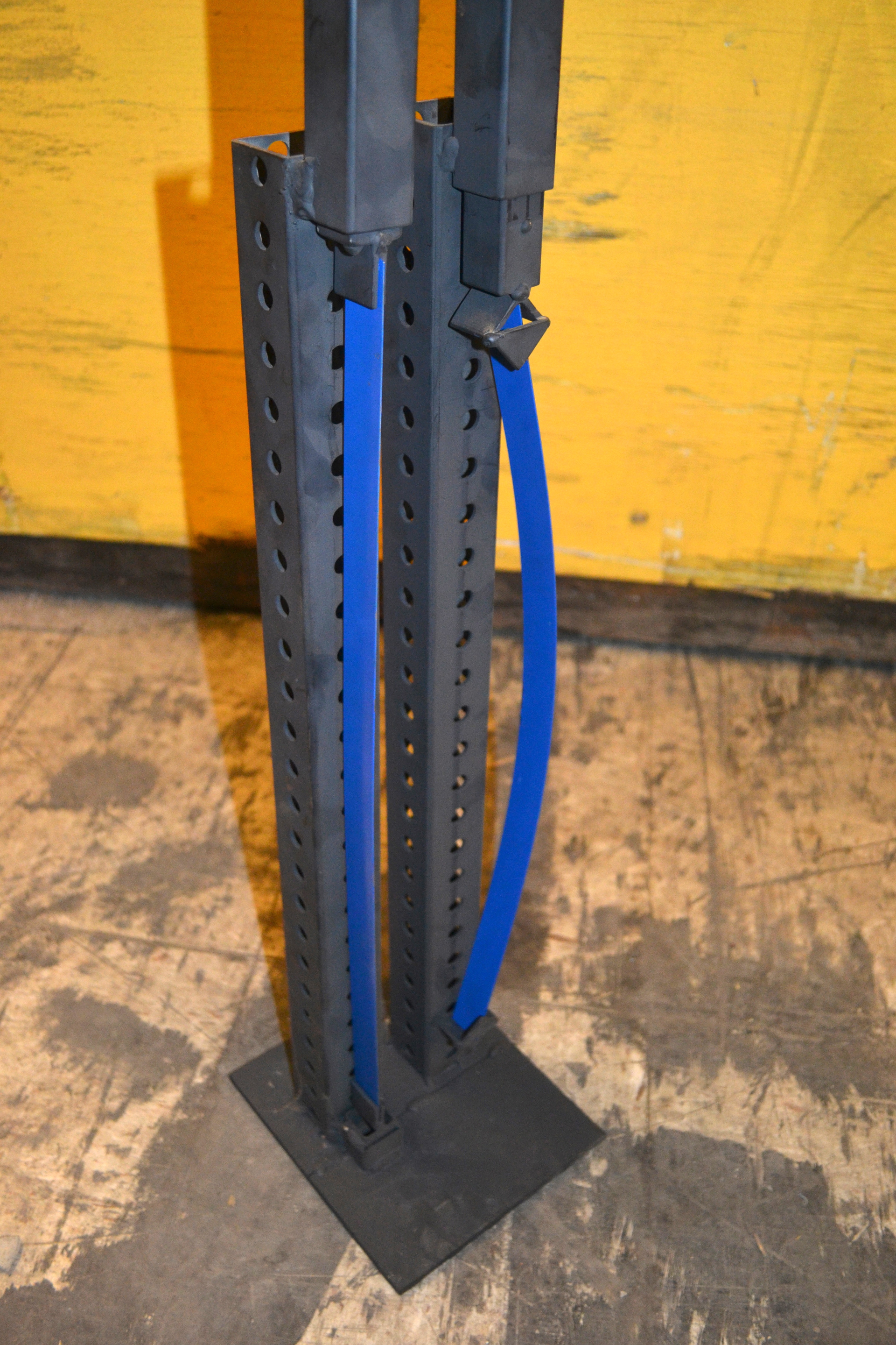 Photo 1: To show that flexible end fittings, such as a hinged base, can make a difference in a strut&rsquo;s working load limit, equal weights were placed at the top of each steel band. (The band on the right has V-shaped end fixtures at the top and is wide open at the bottom. The band on the left has rigid, fixed end fittings.) The steel band that has the rigid end fittings (similar to fixed ends for struts that are used in a trench rescue application) holds up well. The other band buckles under the same weight. Without rigid ends, the steel band is allowed to move and flex under the load.