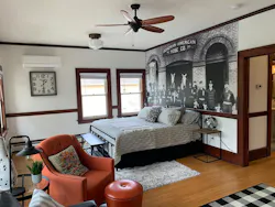 The bedroom of the 800-square-foot second floor features a photo of the firefighters and horses assigned to the station and other memorabilia. The bedroom of the 800-square-foot second floor features a photo of the firefighters and horses assigned to the station and other memorabilia.