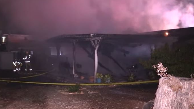 Smoke rises from a Santee, CA, home that burned in a suspected arson fire on Saturday, Nov. 6, 2021.