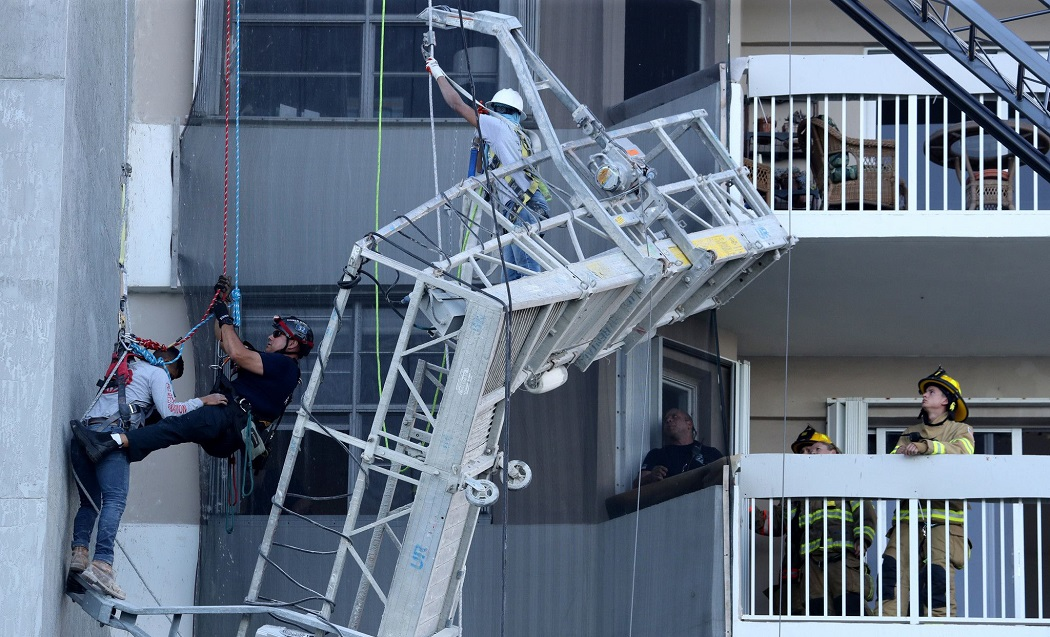 Firefighters prepare to lower a worker to safety after their scaffold collapsed.