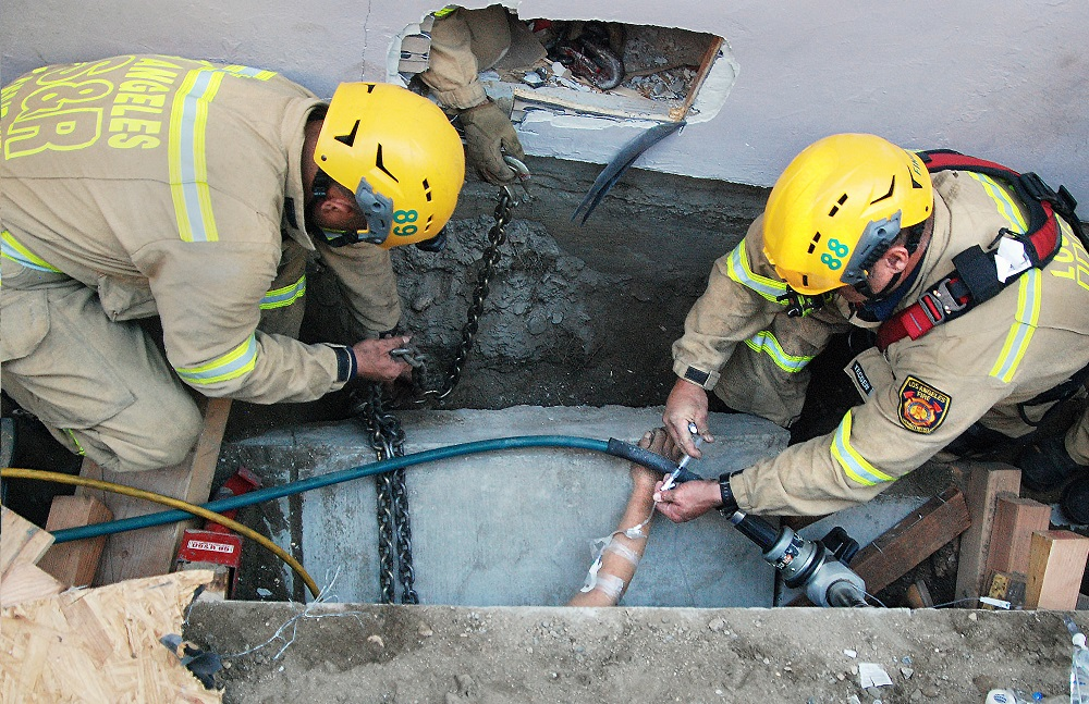 Los Angeles firefighters provide medical care while working to extricate a trench collapse victim.