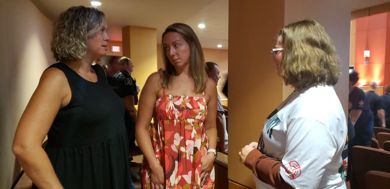 After addressing her late husband's fellow firefighters, Sara Laird, left, talks with Celeste Flynn, center, and her daughter, Erin Laird.