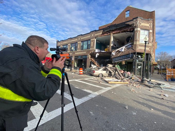 A firefighter uses a laser to search for movement in a building.