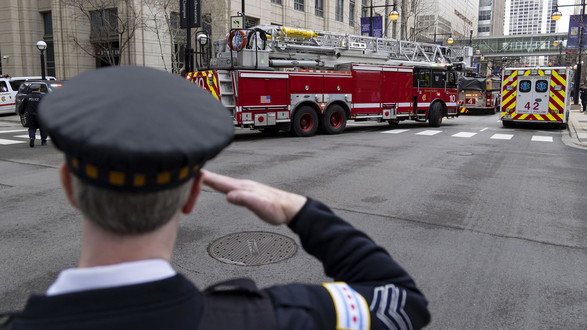 A Chicago police officer salutes as an ambulance carrying the body of fallen Chicago firefighter Lt. Jan Tchoryk departs Northwestern Memorial Hospital on April 5.