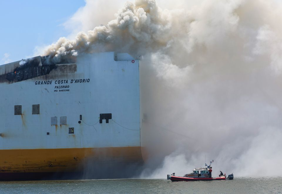 Smoke pours from the Grande Costa D'Avorio cargo ship Thursday afternoon, hours after two Newark firefighters died while battling a fire reported Wednesday night.