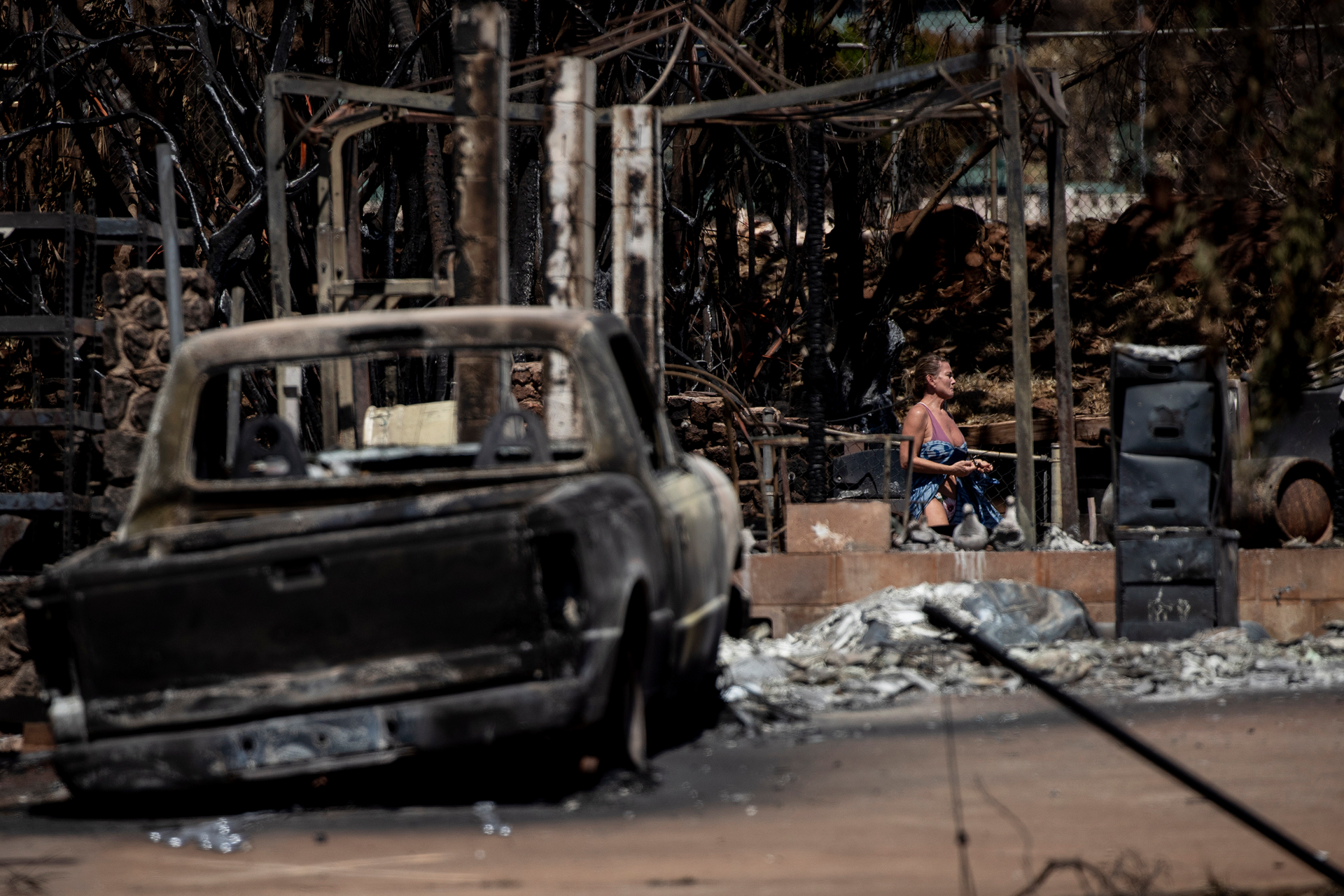 A resident reacts as she walks through the ruins of a a house destroyed by the Lahaina Fire, in Lahaina, in Maui, on Aug. 15, 2023.