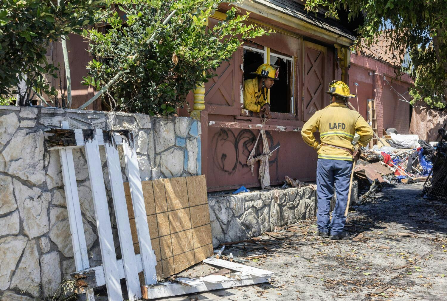Firefighters overhaul the scene after a fire at the historic Pacific Dining Car restaurant on Saturday, Aug. 3,