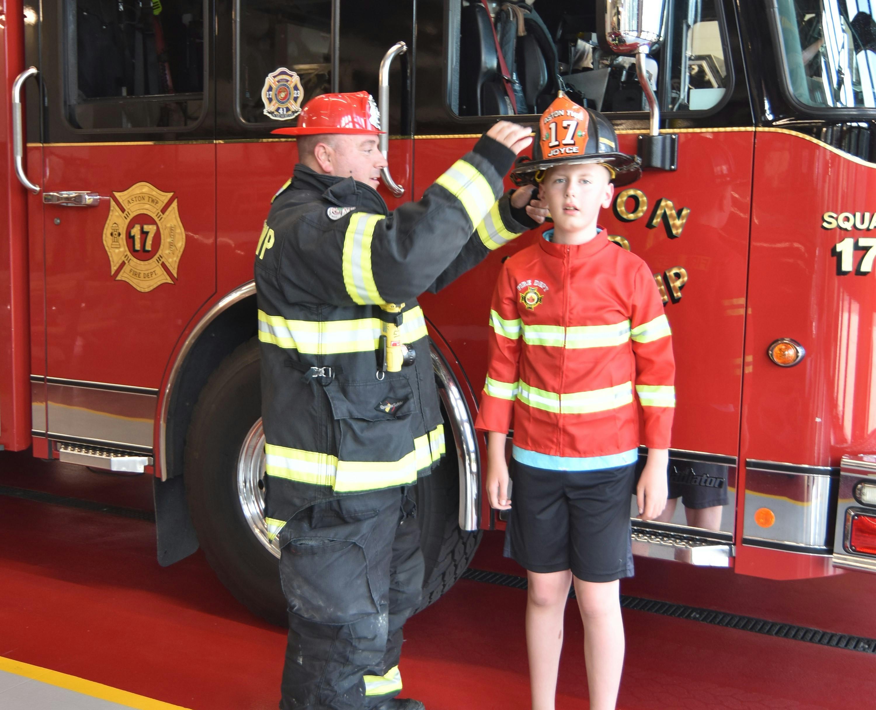 Jaxon Aldridge and Firefighter Sean Joyce of the Aston Township, PA, Fire Department&rsquo;s (ATFD) exchange hats as they talk about what real firefighters wear.