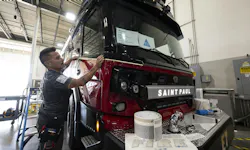 Adam Brinkman, with Grafix Shoppe, applies trim decals on to a Rosenbauer RTX fire engine. Adam Brinkman, with Grafix Shoppe, applies trim decals on to a Rosenbauer RTX fire engine.