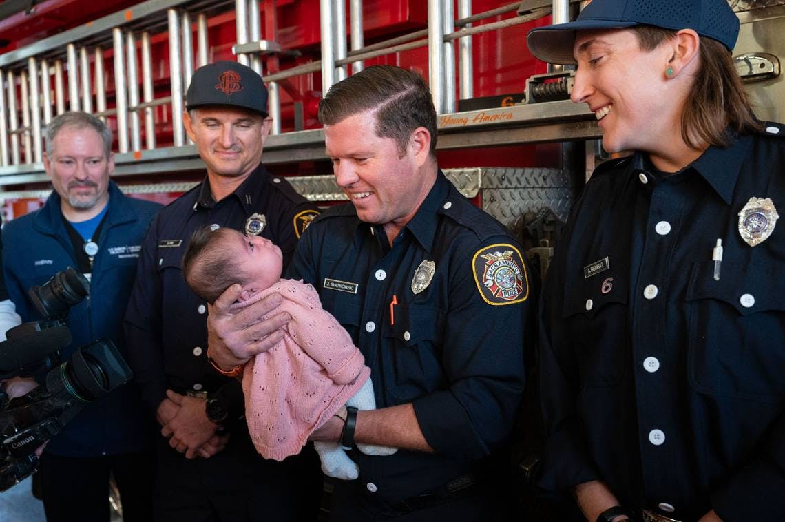 Sacramento Firefighter Jeff Switkowski holds baby Daleyza when they were reunited at Station 6 after they saved the newborn.