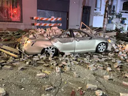Two cars parked outside the building were damaged when the structure collapsed. Two cars parked outside the building were damaged when the structure collapsed.