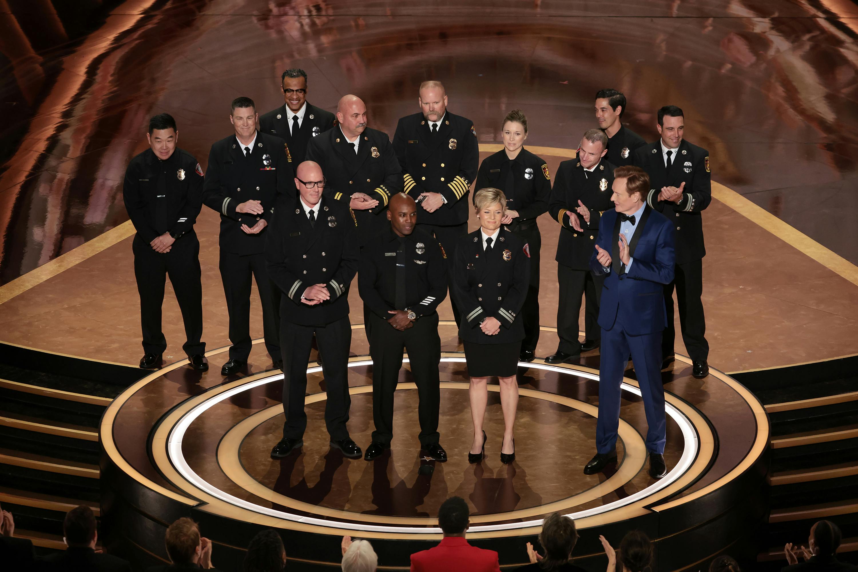 Firefighters from California join Oscars host Conan O'Brien on stage during a tribute to their valiant efforts for January's wildfires during Sunday night's 97th Academy Awards at the Dolby Theatre.