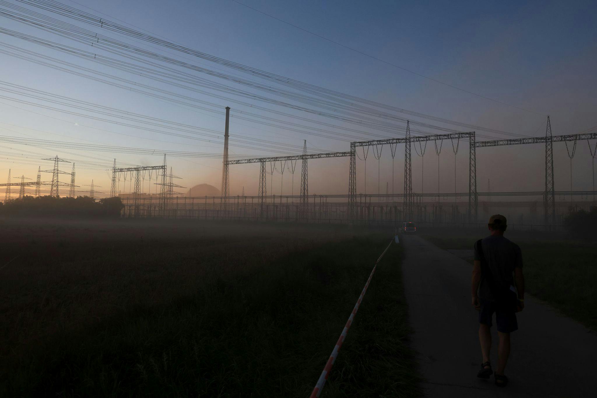 The reactor of the decommissioned nuclear power plant can be seen behind a cloud of dust after the cooling towers were blown up. Eleven workers have been injured in a fire during demolition work at a decommissioned nuclear power plant in southern Germany, police said on Wednesday